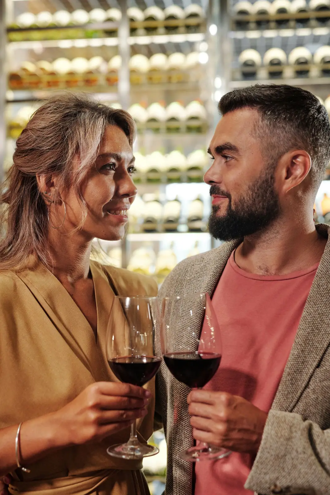 A couple laughing over a glass of wine on a date